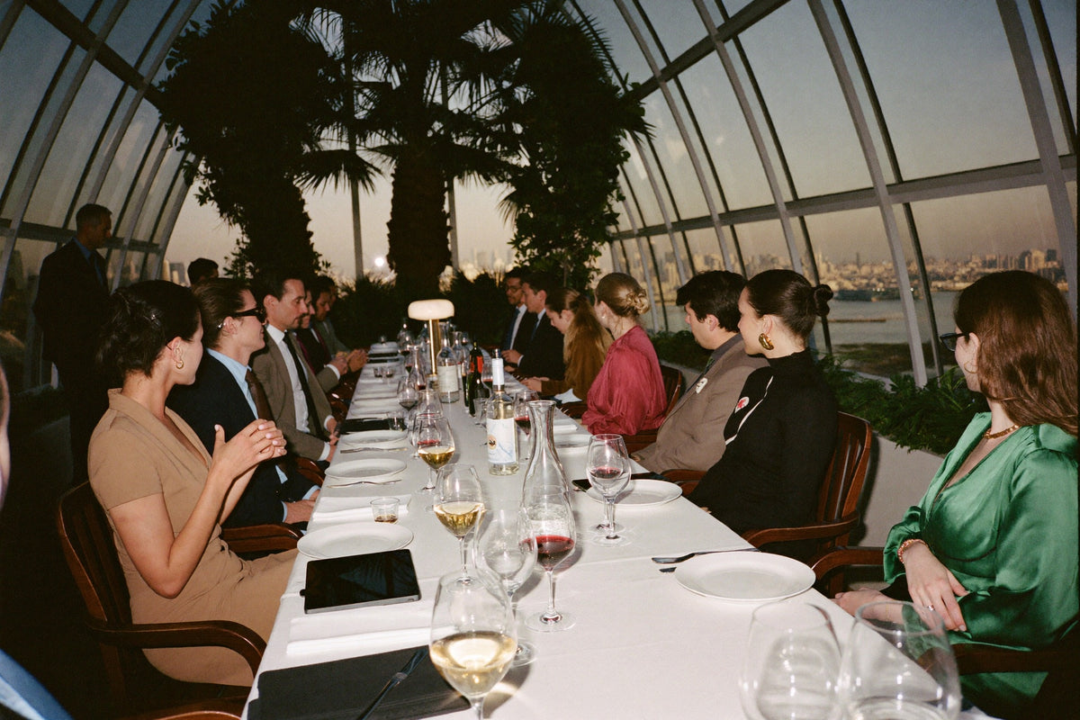A long table set for dinner in a glasshouse